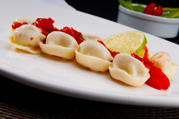 Close-up of tortelini garnished with tomato concasse