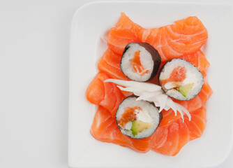 High angle view of sushi rolls on salmon slices