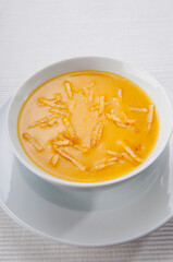Pumpkin soup being poured into a bowl