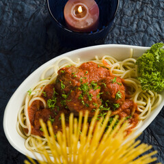Close-up of cooked pasta with a burning candle and pasta sticks