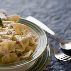 Close-up of a bowl of bow tie pasta with a fork and a spoon