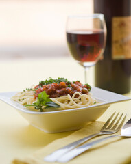 Close-up of spaghetti and meat with red wine