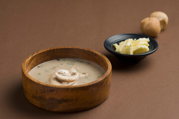 Close-up of a bowl of mushroom soup served with breads and cheese