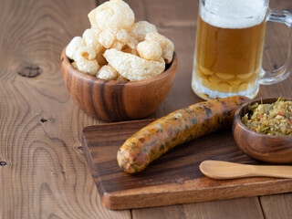 Grilled sausages with beer on wooden table. Top view.