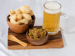 Fast food. A big pork fried with spicy source and a glass of beer. On a wooden background.