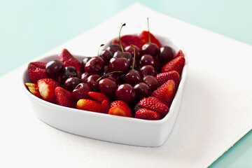 Close-up of a heart shaped bowl filled with assorted berries