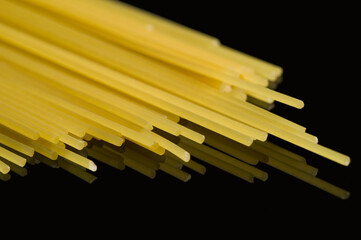 Close-up of raw spaghetti on a black background