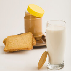Peanut butter jar with a glass of milk and bread slices
