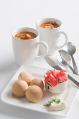Two cups of tomato soup with bread cubes