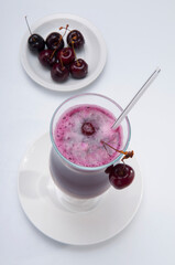 Close-up of a glass of cherry juice with cherries