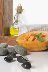 Close-up of papaya with body oil and spa stones