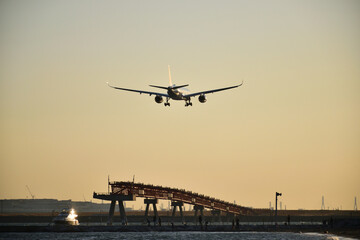 夕暮れの中を着陸する飛行機