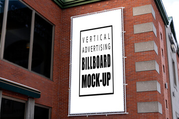 Mock up vertical billboard hanging on the wall of building