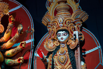 Idol of Goddess Saraswati, decorated Durga Puja pandal, Durga Puja festival at night. Shot under colored light at Howrah, West Bengal, India.