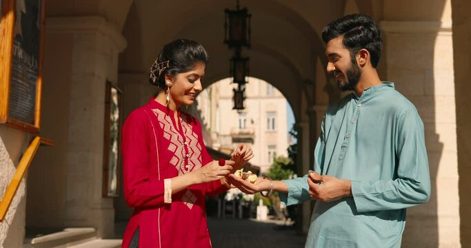 Joyful Hindu young couple having engage at street and woman wearing engaging ring. Wedding in India. Happy male and female in traditional clothes. Outdoors. man and woman in romantic relationships.