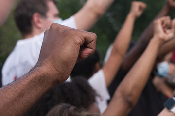 Diverse group of people hold up their fists at a Black Lives Matter protest in New York city 
