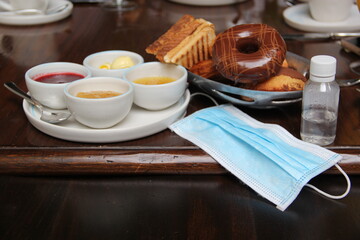 new normal in restaurants, table view with breakfast foods, sweet bread, coffee, juice and natural...