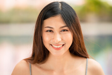 Beautiful young asian woman with natural make up looking at camera and smiling.