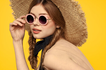 Romantic woman in hat having fun on a yellow background and sunglasses black ribbon model portrait