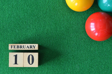 February 10, number cube with balls on snooker table, sport background.