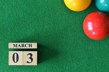 March 3, number cube with balls on snooker table, sport background.