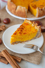 slice of pumpkin pie on plate with pumpkins