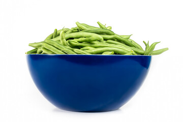 Green bean pods in a large kitchen bowl. Large dark blue plastic mixing bowl with raw green beans spilling over the edge. Fresh picked from garden. Vegetable harvest or arrangement. Isolated on white