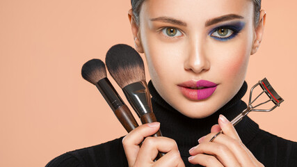 Portrait of a girl with  tools for making makeup near face.  One half face of a beautiful white...