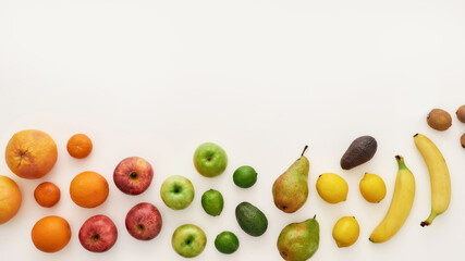 Top view of rainbow composition of various colorful fresh fruits isolated over white background