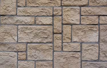 the texture of the new light block masonry of blocks of different sizes beige color on the facade of the building
