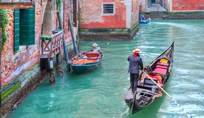 Foto op Aluminium Venetiaanse gondelier punteren gondel door groene kanaalwateren van Venetië Italië © muratart