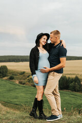 Beautiful pregnant woman and her husband. Couple of people on the background of beautiful nature. selective focus
