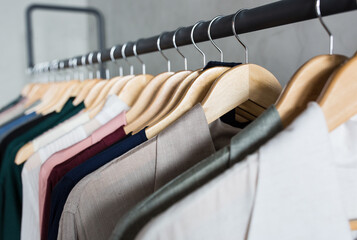 Collection of fashion clothes hanging on a clothing hanger rack in a retail store.