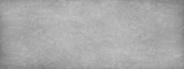 Concrete wall. Wide banner with a rough texture of plaster. Cement background. Abstract gray rough grainy surface texture.