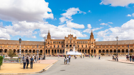 Fototapeta na wymiar Seville, Spain. October 14th, 2019. Plaza de España with tourists strolling admiring the amazing palace and fountain.