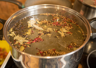 pot with prepared marinade, various peppers, bay leaves and other ingredients
