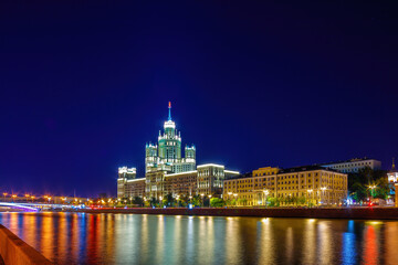 Naklejka premium Stalin Skyscraper on Kotelnicheskaya Embankment of the Moscow River. Night shot of Moscow river reflection.