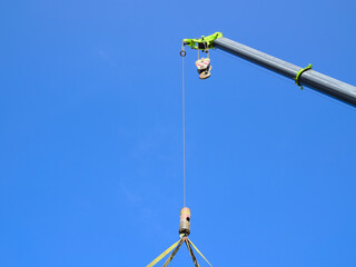 Isolated section of a heavy duty crane machine lifting a container.