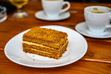 Honey cake and a cup of coffee on a table in a cafe. Sweet breakfast.