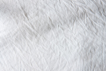 Fototapeta na wymiar Close up shot of white wrinkled cotton fabric which show textile garment detail. Idea for background or wallpaper.