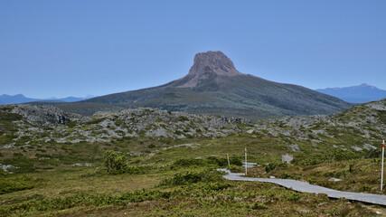 Rocky and steep mountain summit and green grassland on the Overland Track, Tasmania, Australia
