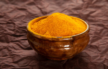 Turmeric powder in a wooden plate. Curcuma spice.