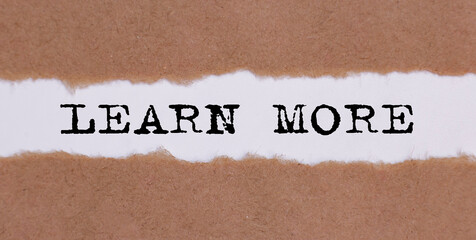 LEARN MORE written under torn paper on white background