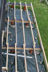 Backyard terrace construction - wooden frame for patio deck with foundation made of pipes filled with concrete. DIY concept.
