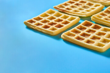 Rows of vanilla belgian waffles on blue background