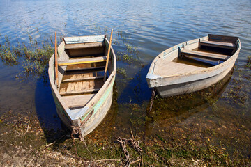 Obraz premium Moored old fishing wooden boats . Two vintage fishing boats in village