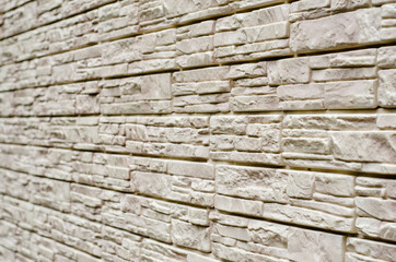 Grey stone background. The walls are decorated with decorative stone. The textured surface is photographed at an angle.