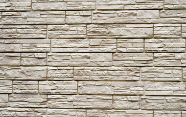 Grey stone background of finishing blocks. The walls are decorated with decorative stone. Textured surface.