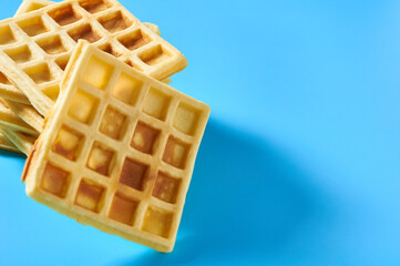 Stack of vanilla belgian waffles on blue background
