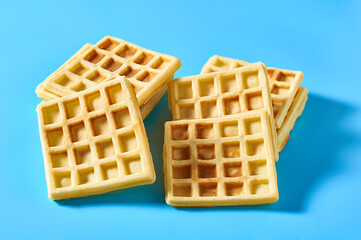 Stack of vanilla belgian waffles on blue background